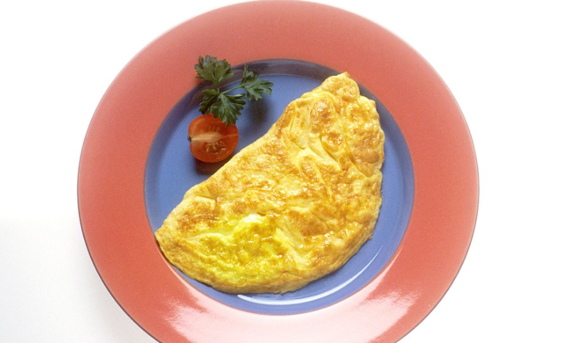a plate of omelette and tomato