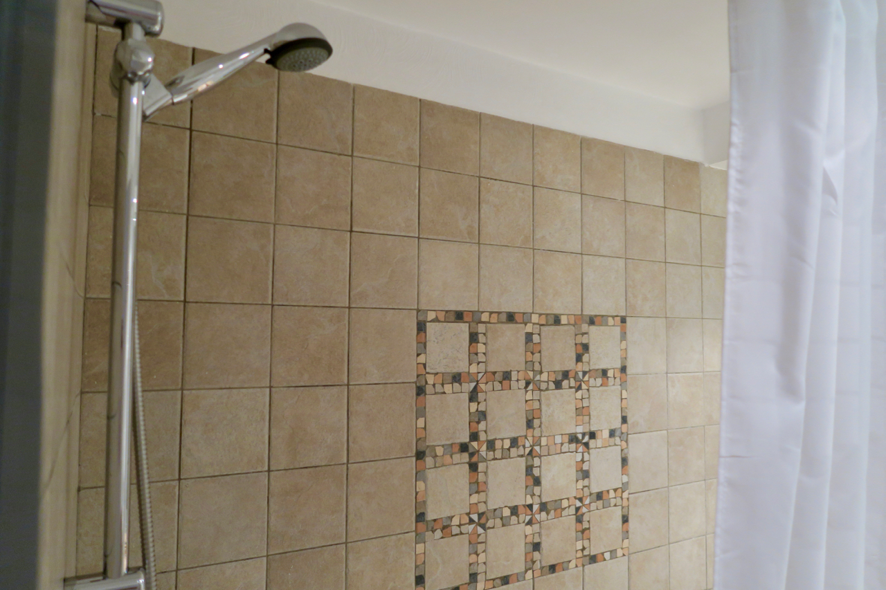 a shower head with a tile wall