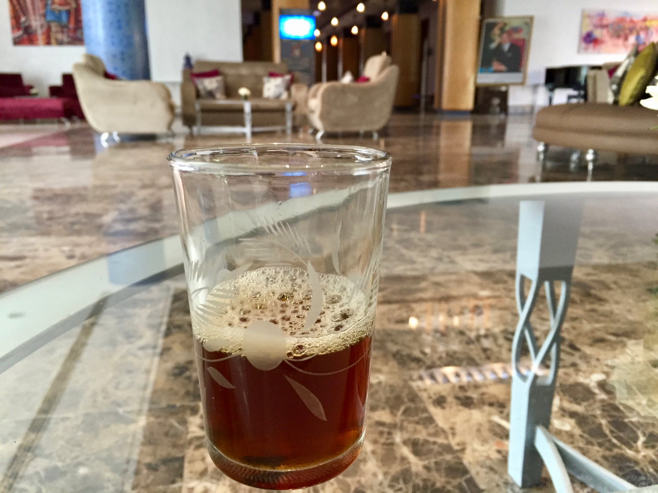 a glass with brown liquid on a table
