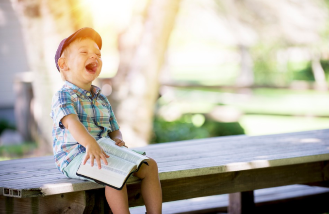 a child sitting on a bench laughing