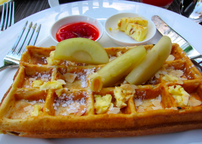 a waffle with fruit and sauce on a plate