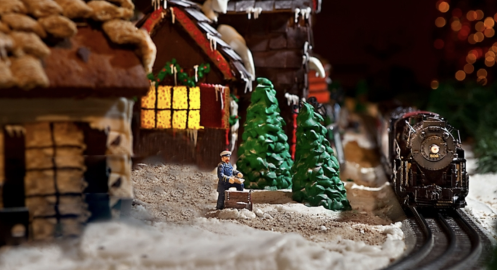 a small toy figure in front of a gingerbread house