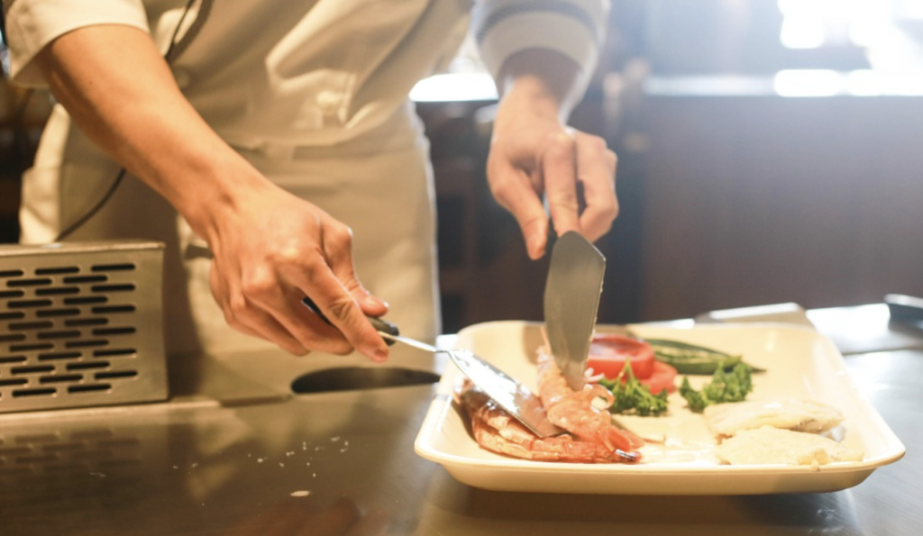 a person cutting meat on a plate